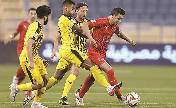 لاعب الدحيل المساكني في صراع على الكرة مع لاعبي قطر