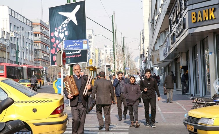 إيرانيون يسيرون قرب لافتة في احد شوارع طهران امس تعبر عن التعاطف مع ضحايا الطائرة الاوكرانية التي تحطمت الأسبوع الماضي	(ا.ف.پ)