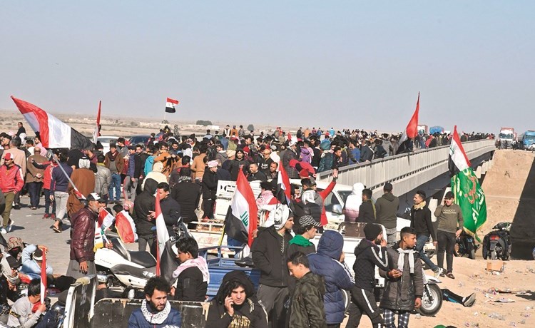 متظاهرون عراقيون خلال اغلاقهم احد أكبر الجسور جنوبي الناصرية أمس	(ا.ف.پ)