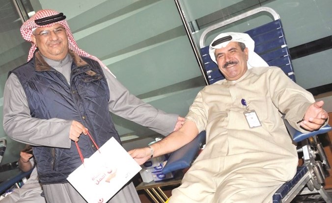 محمد الحميضي مشاركا في حملة التبرع بالدم ويبدو إبراهيم الربيعان(محمد هنداوي)