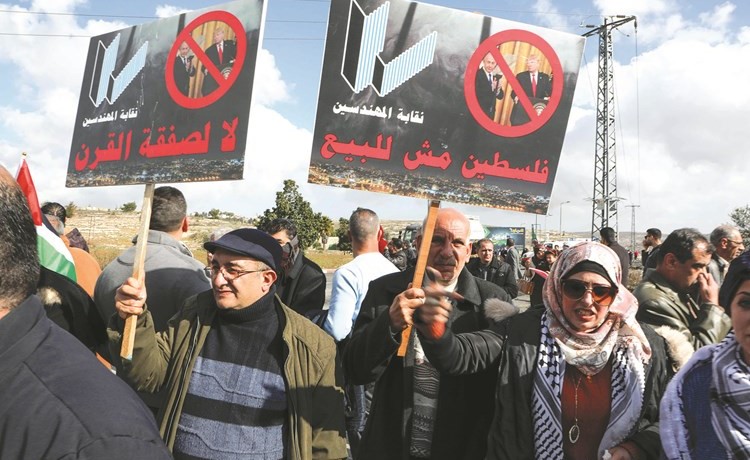 فلسطينيون غاضبون يرفعون لافتات مناهضة لـصفقة القرن خلال احتجاجات في رام الله أمس	(ا.ف.پ)
