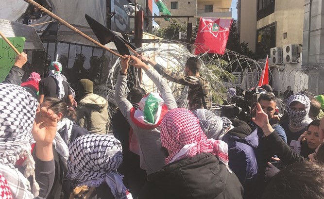 مجموعة من الحراك اليساريخلال قطع الاسلاك الشائكة اثناءتظاهرة في محيط السفارة الاميركية في عوكر	(محمود الطويل)