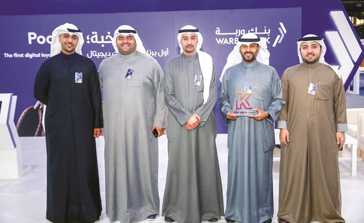أيمن المطيري مع فريق عمل وربة في جناح البنك المشارك بالمعرض