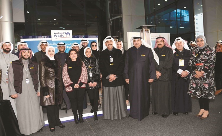 مريم العقيل وأحمد الموسى وعدد من الحضور خلال جولة في أجنحة المصارف المشاركة في المعرض