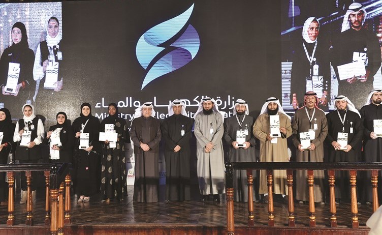 د.خالد الفاضل وم.محمد بوشهري يتوسطان الفائزين بالجائزة خلال الحفل	(متين غوزال)