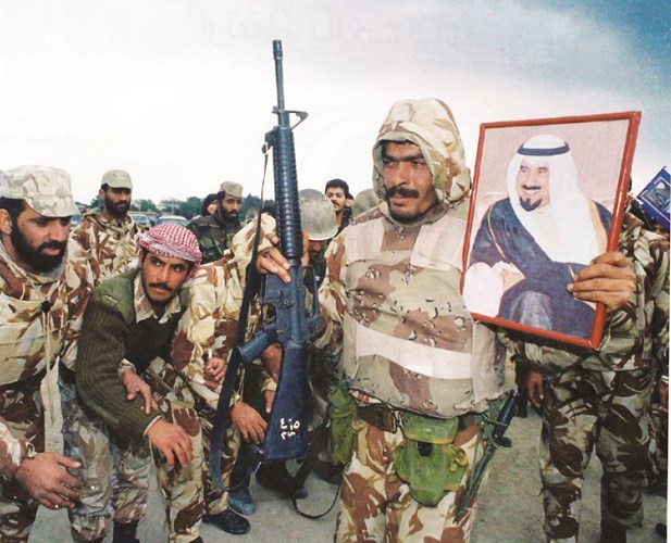 جندي يحمل صورة سمو الامير الراحل الشيخ جابر الاحمد خلال حرب التحرير