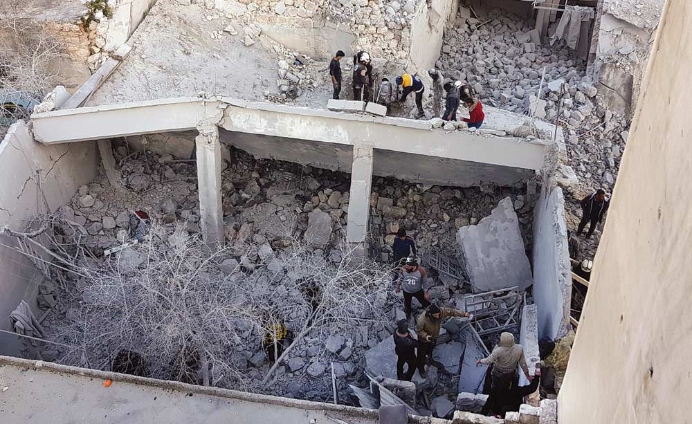 محاولات البحث عن ناجين تحت انقاض مبنى دمرته غارات على بلدة بنش بإدلب (ا.ف.پ)