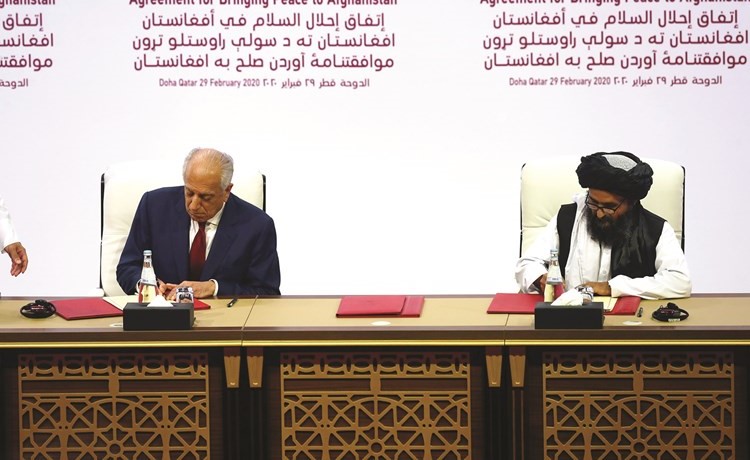 المبعوث الأميركي للمصالحة الافغانية زلماي خليل زاد ورئيس المكتب السياسي لـطالبان الملا عبد الغني برادار يوقعان اتفاق السلام التاريخي في الدوحة أمس	(رويترز)