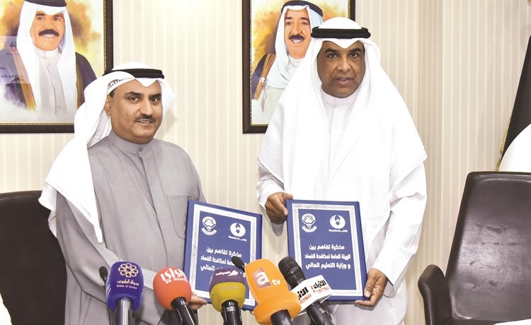 د.سعود الحربي والمستشار عبدالرحمن النمش يتبادلان وثيقة الاتفاقية (محمد هنداوي)