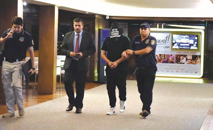 الشرطة الباراغويانية تقتاد شخص غير معروف لوسائل الاعلام في نفس الفندق الذي يقيم فيه رونالدينيو (ا.ف.ب)