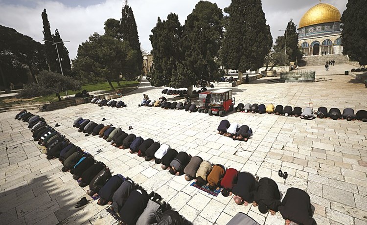 مصلون يؤدون الصلاة في ساحات المسجد الاقصى بعد اغلاق مصلياته المسقوفة بسبب كورونا	(رويترز)