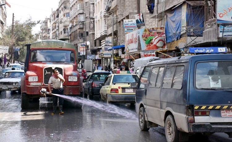 موظف بلدية يقوم بتعقيم أحد شوراع حلب	( أ.ف.پ)