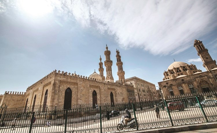 مصريون يمرون بالقرب من جامع الأزهر عقب قرار إغلاقه أمس 	(أ.ف.پ)