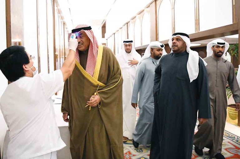  سمو رئيس الوزراء الشيخ صباح الخالد أثناء فحص درجة الحرارة قبيل دخوله إلى قاعة عبدالله السالم أمس ضمن إجراءات المجلس الاحترازية لمواجهة ڤيروس كورونا ويبدو الشيخ أحمد المنصور ود. فهد العفاسي 