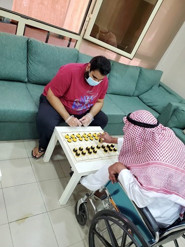 لعب الدامة مع أحد المسنين
