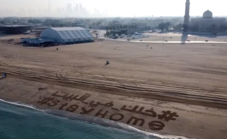 رسالة على رمال شاطئ دبي لمواجهة كورونا