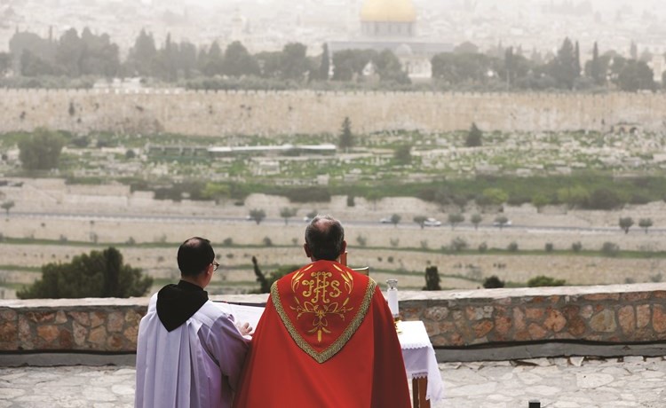 رجلا دين مسيحيان يؤديان الصلاة على جبل الزيتون قبالة قبة الصخرة	(رويترز)