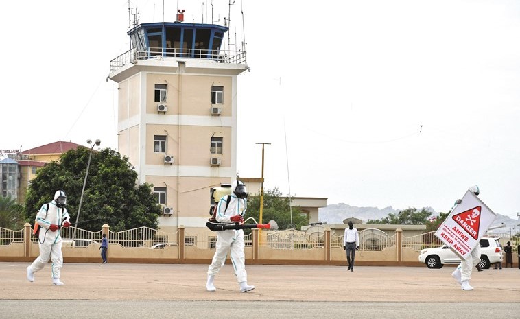 أعضاء فريق طبي يرتدون بدلات واقية يعقمون مطار جوبا الدولي(رويتر)