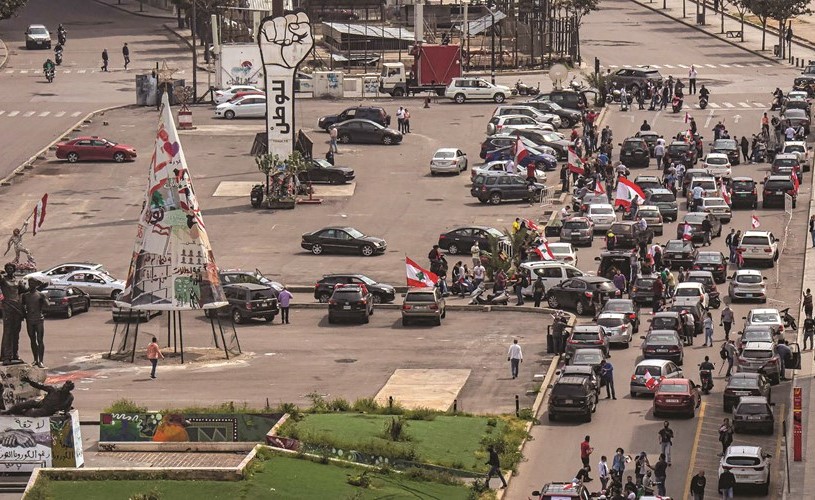 مجموعة من المحتجين خلال مسيرة سيارة في شوارع بيروت رافعين الأعلام مؤكدين على استمرار الثورة (محمود الطويل)