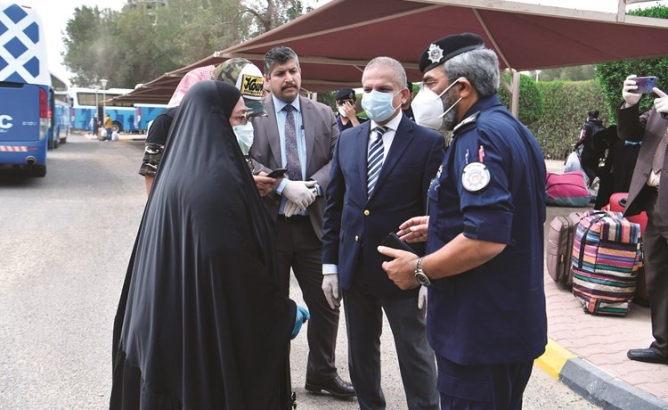 العميد إياد الحداد والقائم بالأعمال في السفارة العراقية محمد الحسيني يتحدثان إلى إحدى المواطنات العراقيات المغادرات