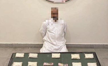 المتهم وأمامه الحبوب المهربة