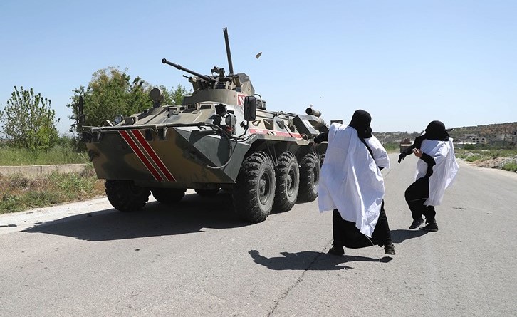محتجنان ترميان ناقلة جند روسية بالحجارة خلال دورية مشتركة مع القوات التركية على طريق ام 4 قرب اريحا	(أ.ف.پ)