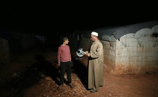بالفيديو.. مسحراتي رمضان يوقظ النازحين في مخيم في شمال غرب سوريا