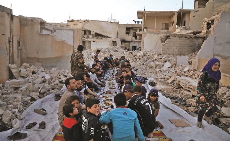 افطار جماعي وسط الدمار في قرية كفر نوران بريف حلب الغربي	(أ.ف.ب)