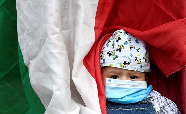 طفل التزم الإجراءات الاحترازية في وقفة احتجاجية بميلان(رويترز)