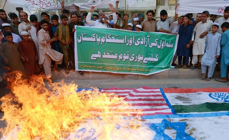 مسلمون يحرقون اعلام اسرائيل والولايات المتحدة والهند في بيشاور في الجمعة الأخيرة من رمضان دعما للقدس	 				(أ.ف.پ)
