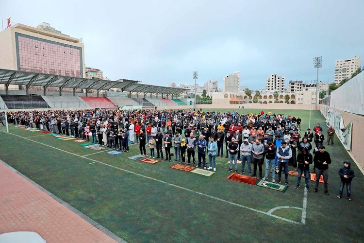 فلسطينيون يقيمون صلاة عيد الفطر في احدى ساحات الضفة المحتلة (أ.ف.پ)
