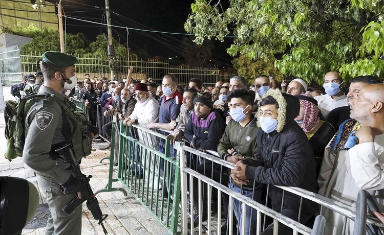 فلسطينيون ينتظرون قرب الحرم الإبراهيمي في الخليل أمس بعدما قلصت إسرائيل عدد المصلين المسموح لهم بالصلاة فيه 	(أ.ف.پ)