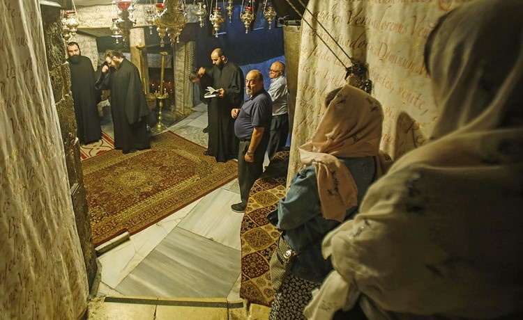 مسيحيون يؤدون الصلوات في كنيسة المهد بعد اعادة فتحها 	(أ.ف.پ)