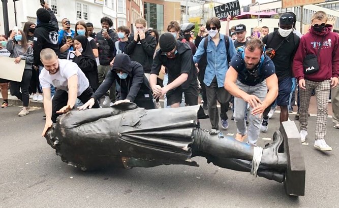 متظاهرون بريطانيون يدحرجون التمثال قبل إلقائه في النهر