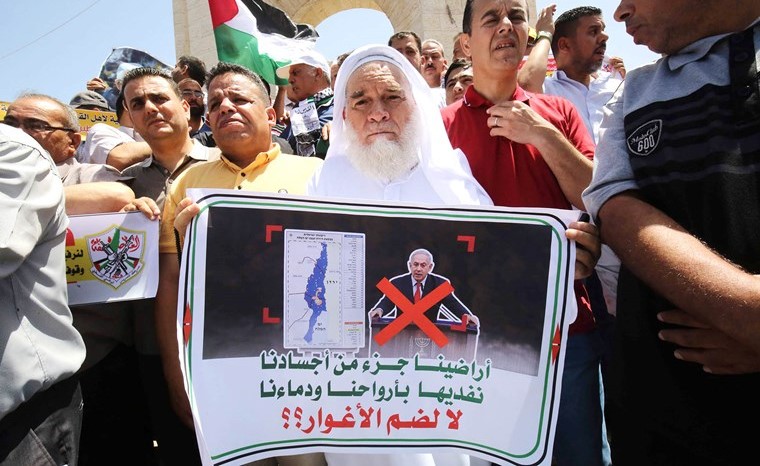 فلسطينيون يرفعون لافتات رافضة لـخطة الضم الاسرائيلية- الاميركية خلال احتجاجات في غزة أمس	(ا.ف.ب)