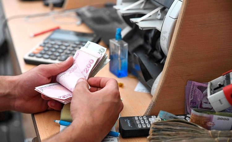 موظف في مكتب صرافة يعد الليرات التركية التي اصبح التعامل بها شائعا في محافظة ادلب عقب انهيار العملة السورية(أ.ف.پ)