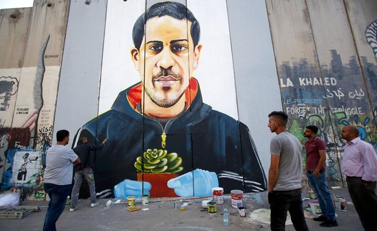 لوحة جدارية ضخمة للشهيد إياد الحلاق على الجدار العازل في الضفة الغربية المحتلة	 (ا.ف.ب)