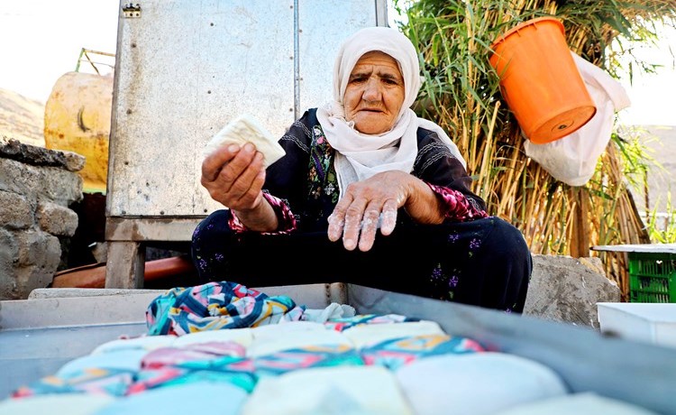 عجوز فلسطينية تصنع الجبن في منزلهاامس بغور الأردن الذي تخطط إسرائيل لضمه بداية يوليو المقبل		 (ا.ف.پ)