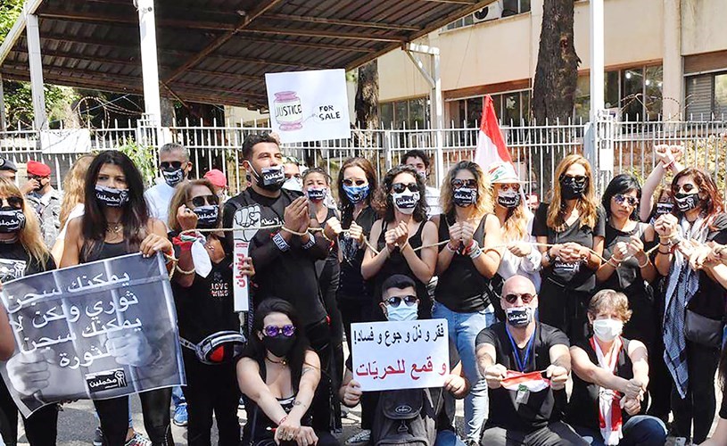 عدد من الناشطين خلال وقفة رمزية أمام ​قصر العدل ​رفضا لملاحقة معارضي ​رئيس الجمهورية​(محمود الطويل)