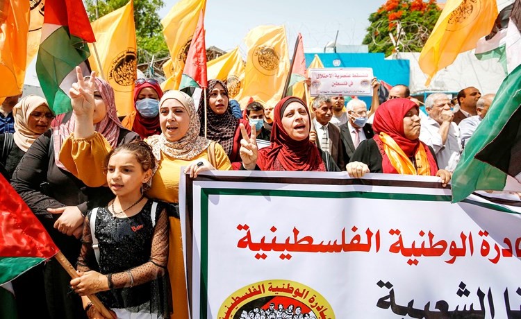 فلسطينيون يرفعون لافتات تدعو للوحدة الوطنية خلال تظاهرة في غزة احتجاجا على خطط الضم الاسرائيليةامس	(ا.ف.پ)