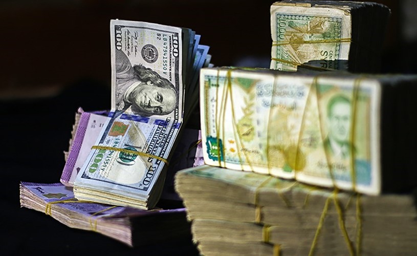 صور تعبيرية للعملة السورية والدولار الأميركي