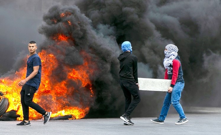 فلسطينيون خلال تظاهرات قرب رام الله احتجاجا على خطط الضم الاسرائيلية امس الاول 				(ا.ف.پ)