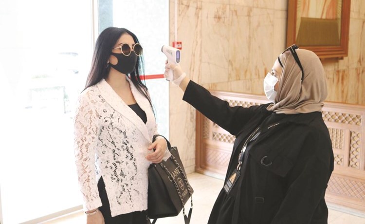 قياس درجة حرارة إحدى الموظفات