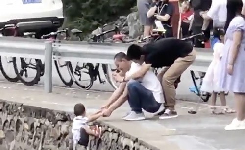 بالفيديو.. أب يغامر بحياة طفله لالتقاط صورة على حافة طريق جبلي !