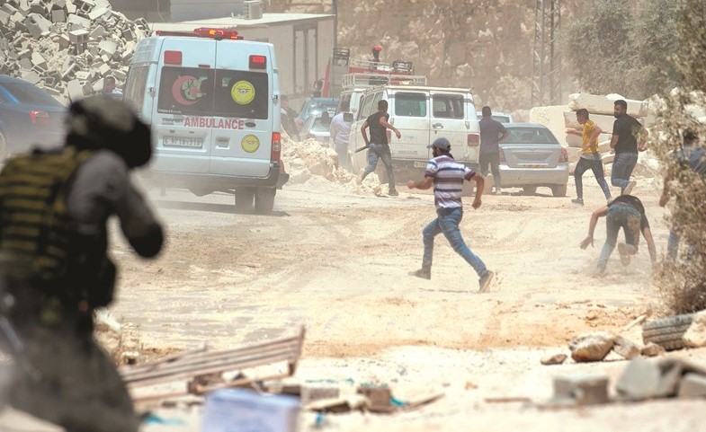 جندي من قوات الاحتلال يطلق النار على شباب فلسطينيين خلال احتجاجات ضد الاستيطان في الضفة امس	(أ.ف.پ)