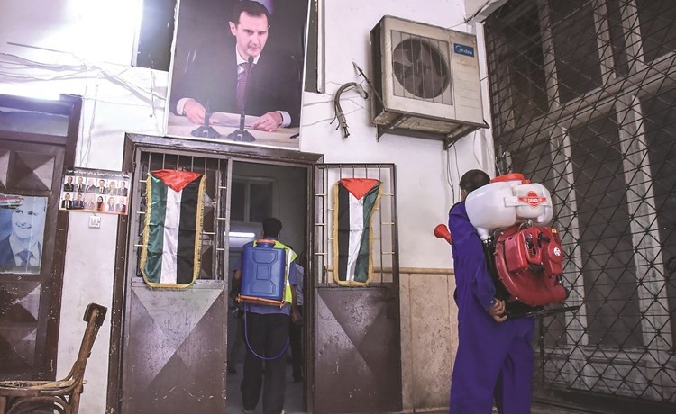 عمال بلدية يطهرون أحد مراكز الاقتراع في حلب	(أ.ف.پ)