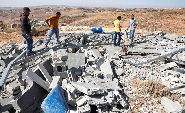 فلسطينيون يتفقدون أنقاض منزلهم بعد ان هدمه الاحتلال	 (أ.ف.پ)