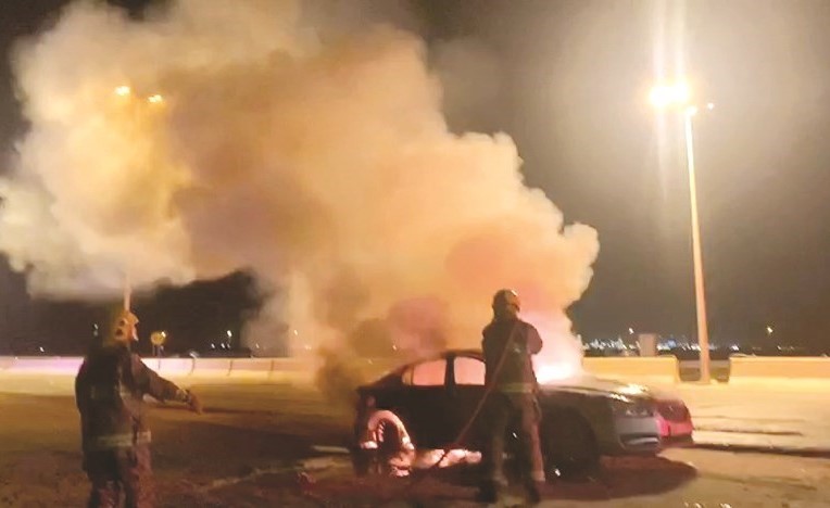 أحد رجال الإطفاء يتعامل مع حريق المركبة