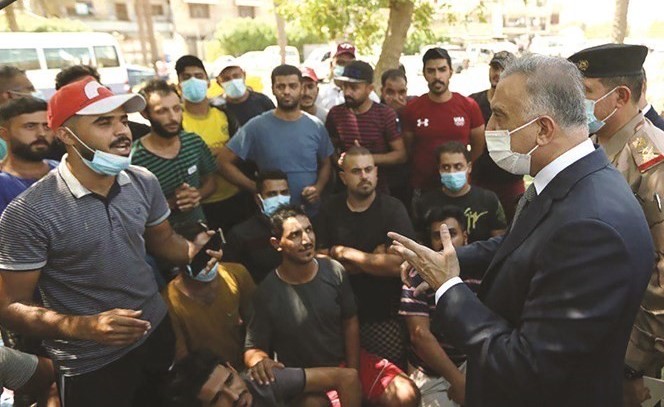 رئيس الوزراء العراقي مصطفى الكاظمي خلال لقائه المتظاهرين ببغداد أمس	 (وسائل التواصل الاجتماعي)