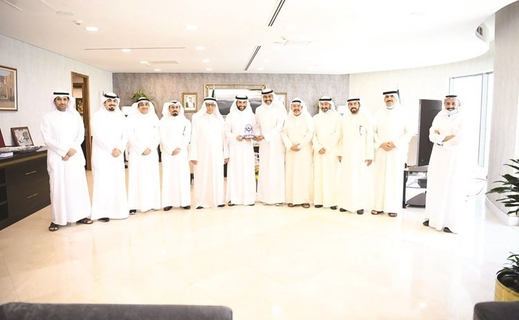 لقطة جماعية لأعضاء مجلس إدارة الجمعية يسلمون درع تكريم لرئيس مجلس الأمة مرزوق الغانم